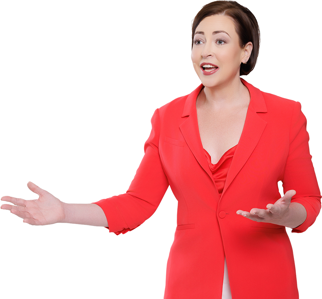 Disruption speaker Lauren Hasson in a reddish coral jacket with her arms stretched out in front of her